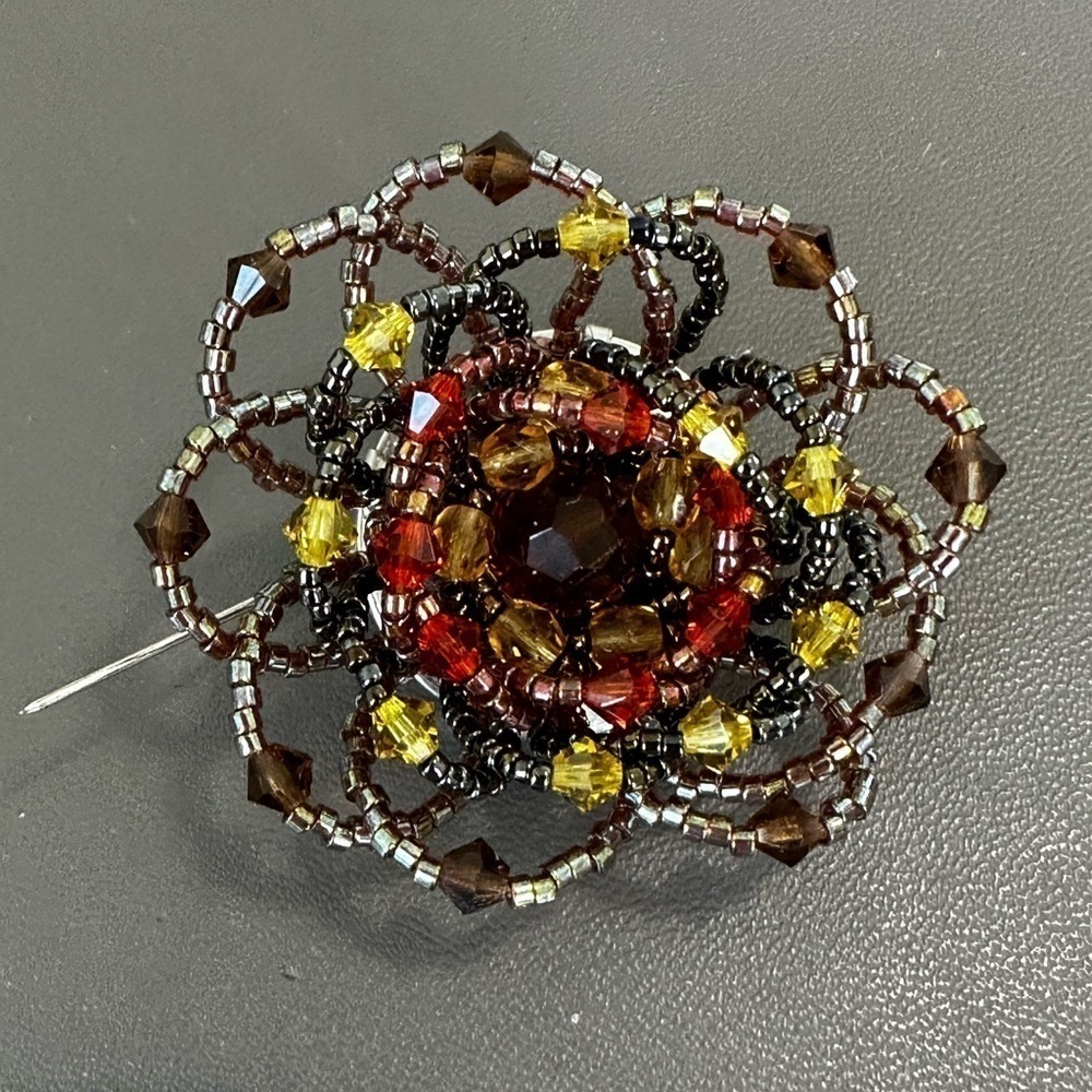 Beaded Brooch 2” wide . Green, brown & amber beads Floral pattern